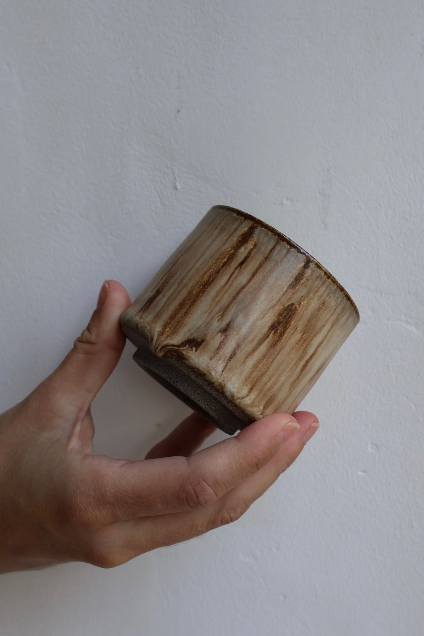 Wooden block held in a hand against a plain background