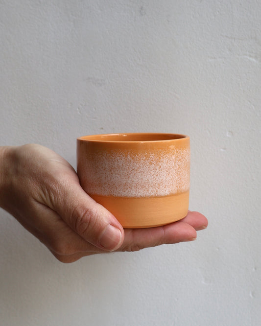 Handmade stoneware tumbler in sunset orange glaze with white crystalline detail — Ela Grima handmade ceramics Malmö & Copenhage
